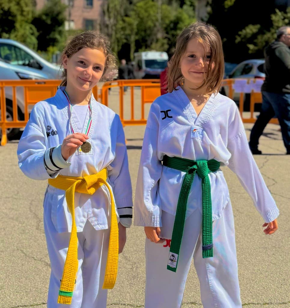 Due allieve di Taekwondo a Ostia in dobok con cinture gialla e verde, una mostra la medaglia